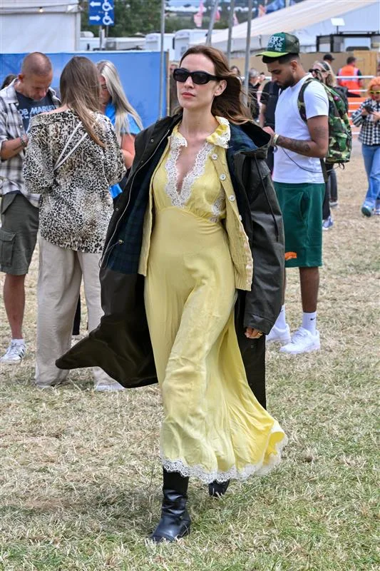 Alexa Chungy wears yellow dress and dark coat at glastonbury
