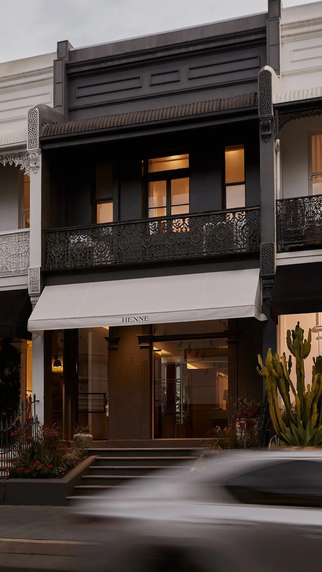 a black and white sydney terrace building with an awning that reads HENNE