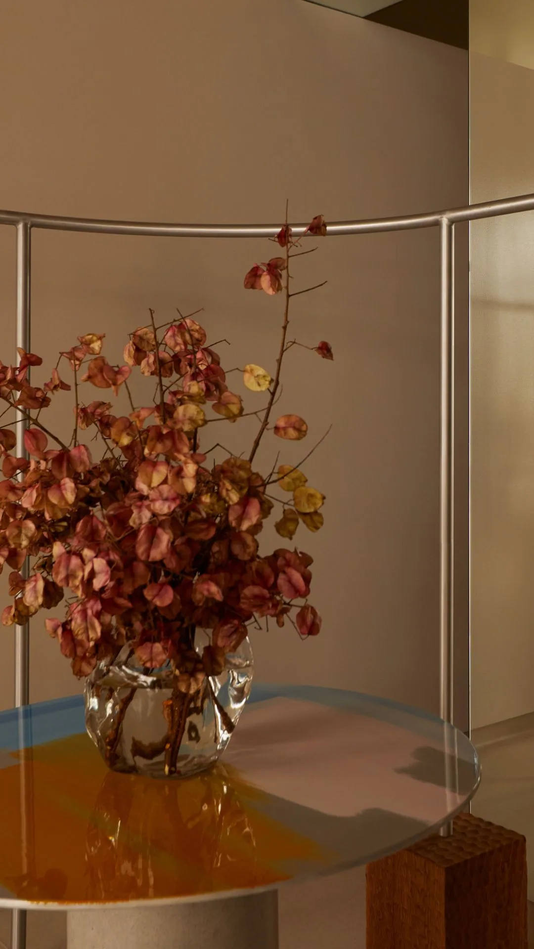 a bunch of flowers sit on a glas table against a cream wall and silver railing in the new henne store in sydney