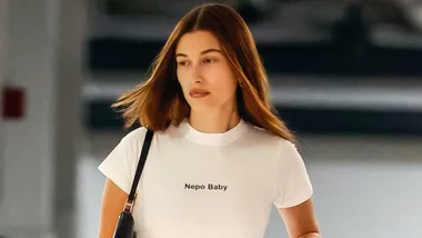 Hailey Bieber wears a white t-shirt that says 'nepo baby' on it.