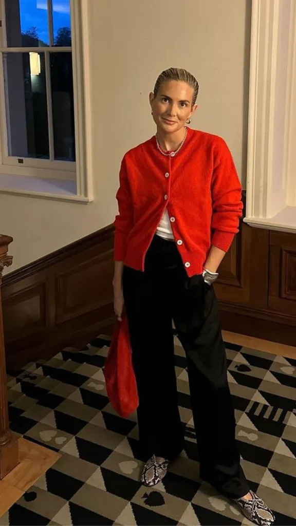 Lucy Williams wears a red cardigan.