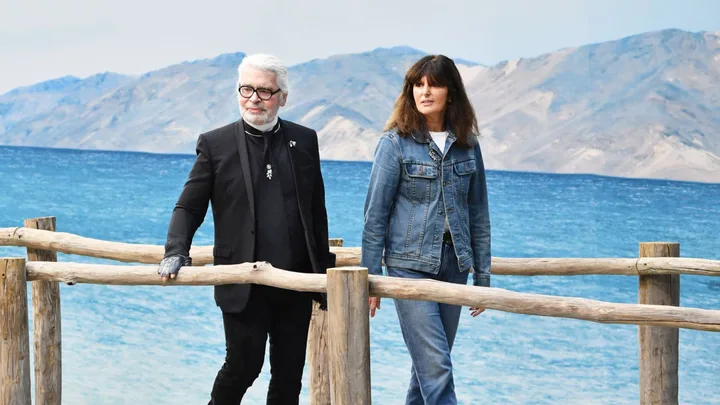 karl lagerfeld and virginie viard walk against the backdrop of the sea