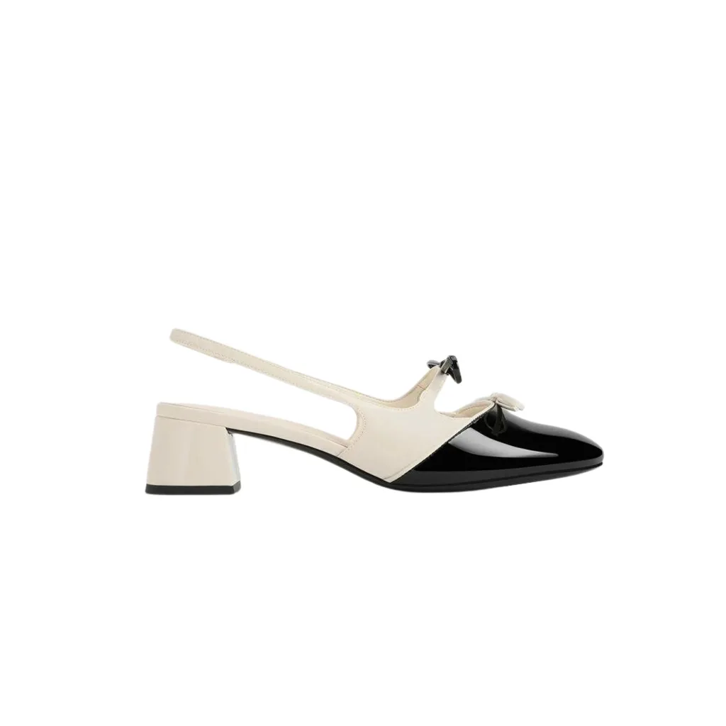 Charles & Keith Dorr Two-Toned Double Bow Slingback Pumps feature low block heels, Mary Jane straps and bows. The chalk colourway pictured is a off white and black. 