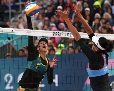 Female beach volleyball players scrap tiny uniform.