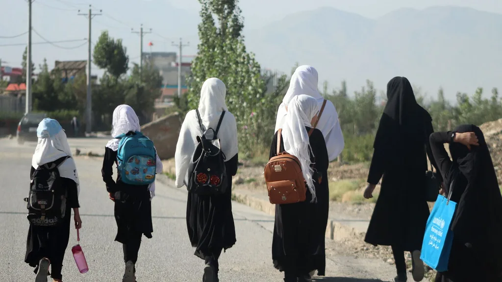 Girls walk to their school along a road in Gardez, Paktia porvince, on September 8, 2022. - Five government secondary schools for girls have resumed classes in eastern Afghanistan after hundreds of students demanded they reopen, provincial officials said on September 8. Officially the Taliban have banned girls secondary school education, but the order has been ignored in a few parts of Afghanistan away from the central powerbases of Kabul and Kandahar