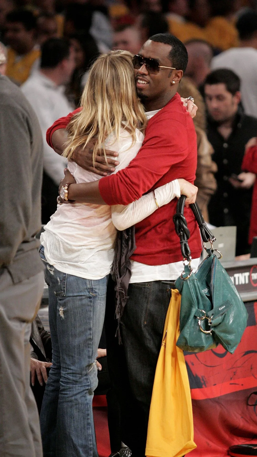 sean diddy combs and Cameron Diaz hugging at a basketball game. 