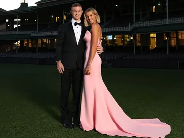 Chad Warner wearing a black tuxedo and white shirt and partner Alice Hughes wearing a long pink strapless gown arrive at Sydney Swans Brownlow Medal Function at Sydney Cricket Ground