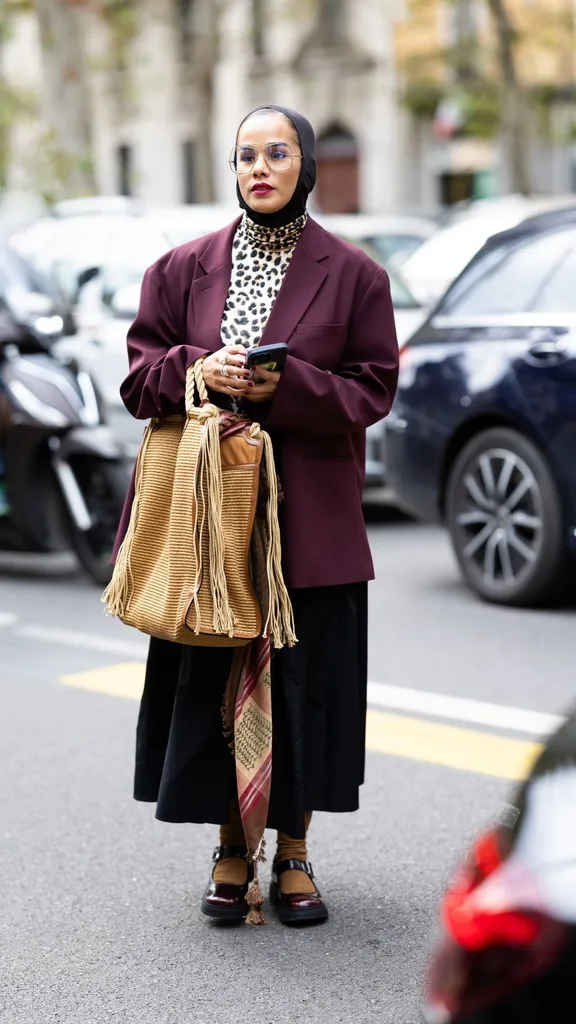 A woman wearing a burgundy blazer, black hijab and leopard print top at Milan Fashion Week