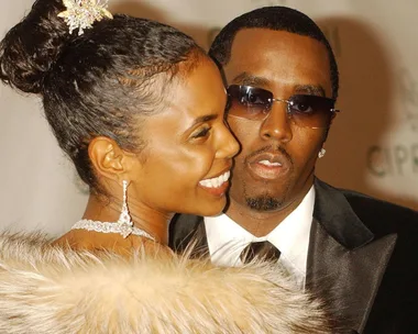 A close-up shot of Kim Porter looking over her shoulder wearing a feathered top with Sean 'Diddy' Combs looking into the camera wearing sunglasses