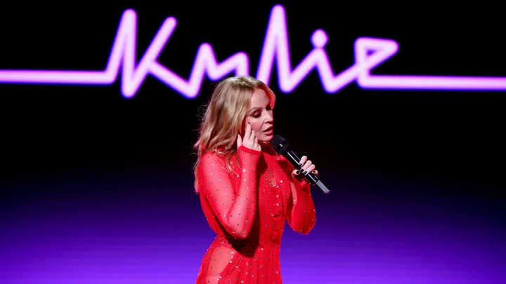 Kylie Minogue performs at the Summer Gala by Gala One at Golf Club Saint-Tropez wearing a red sparkly sheer long sleeve dress