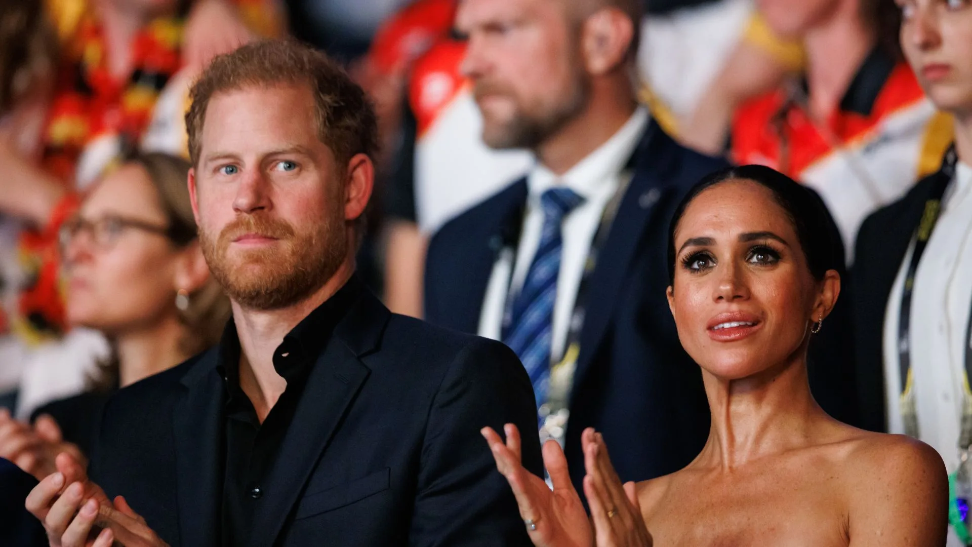 Prince harry and Meghan Markle applaud from crowd