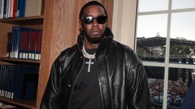 Sean "Diddy" Combs in a black leather jacket and black t shirt with large diamond necklace with a cross.