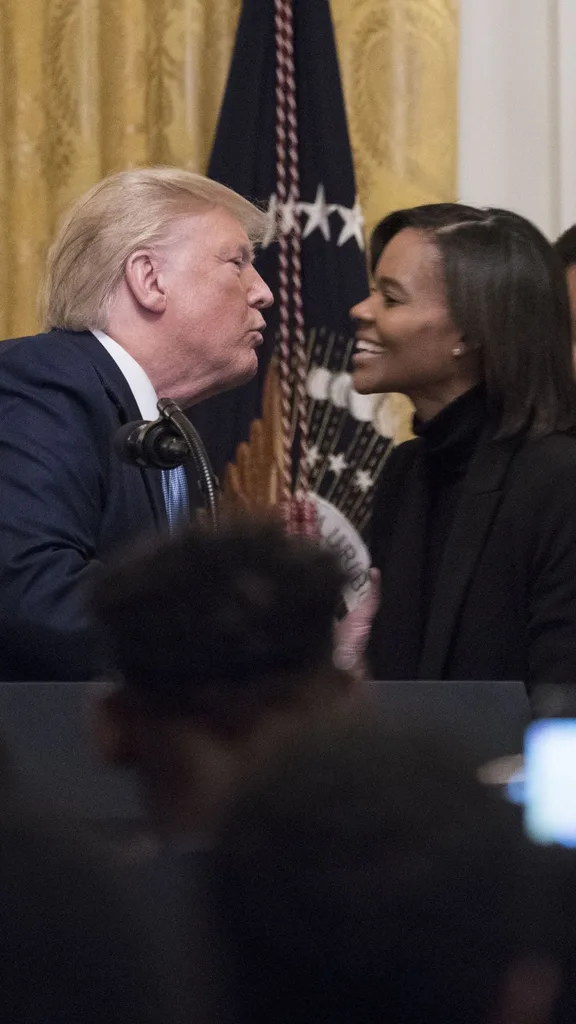 Political commentator Candace Owens, center right, embraces U.S. President Donald Trump, center left, during the Young Black Leadership Summit 2019 event in the East Room of the White House in Washington, D.C., U.S., on Friday, Oct. 4, 2019