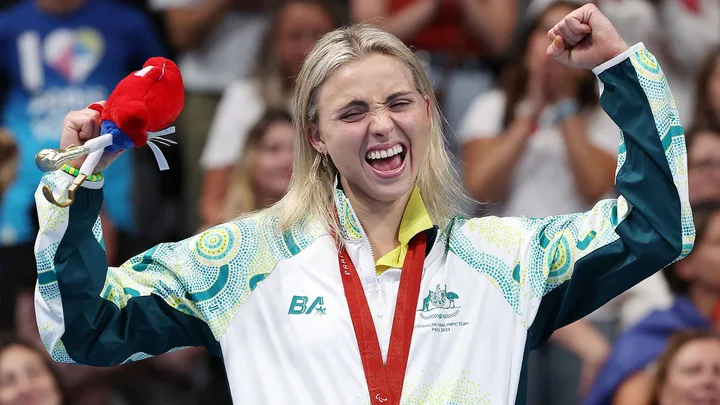 Australian para swimmer Alexa Leary celebrates on the podium after winning gold in the women's 100 metre freestyle.