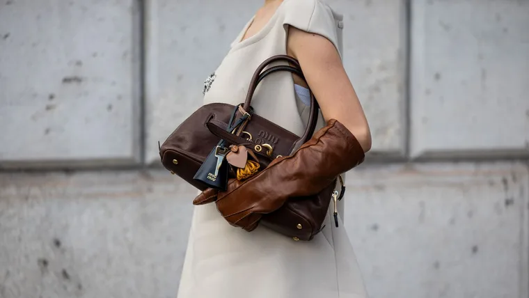 Elva Ni wears brown bag, gloves, sleeveless dress outside Miu Miu during Womenswear SpringSummer 2025