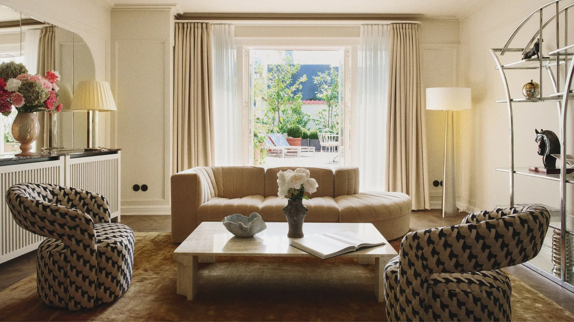 The living area in a Hotel Bella Grande suite looking out to the rooftop terrace through a set of windows in Hotel Bella Grande, Copenhagen. 