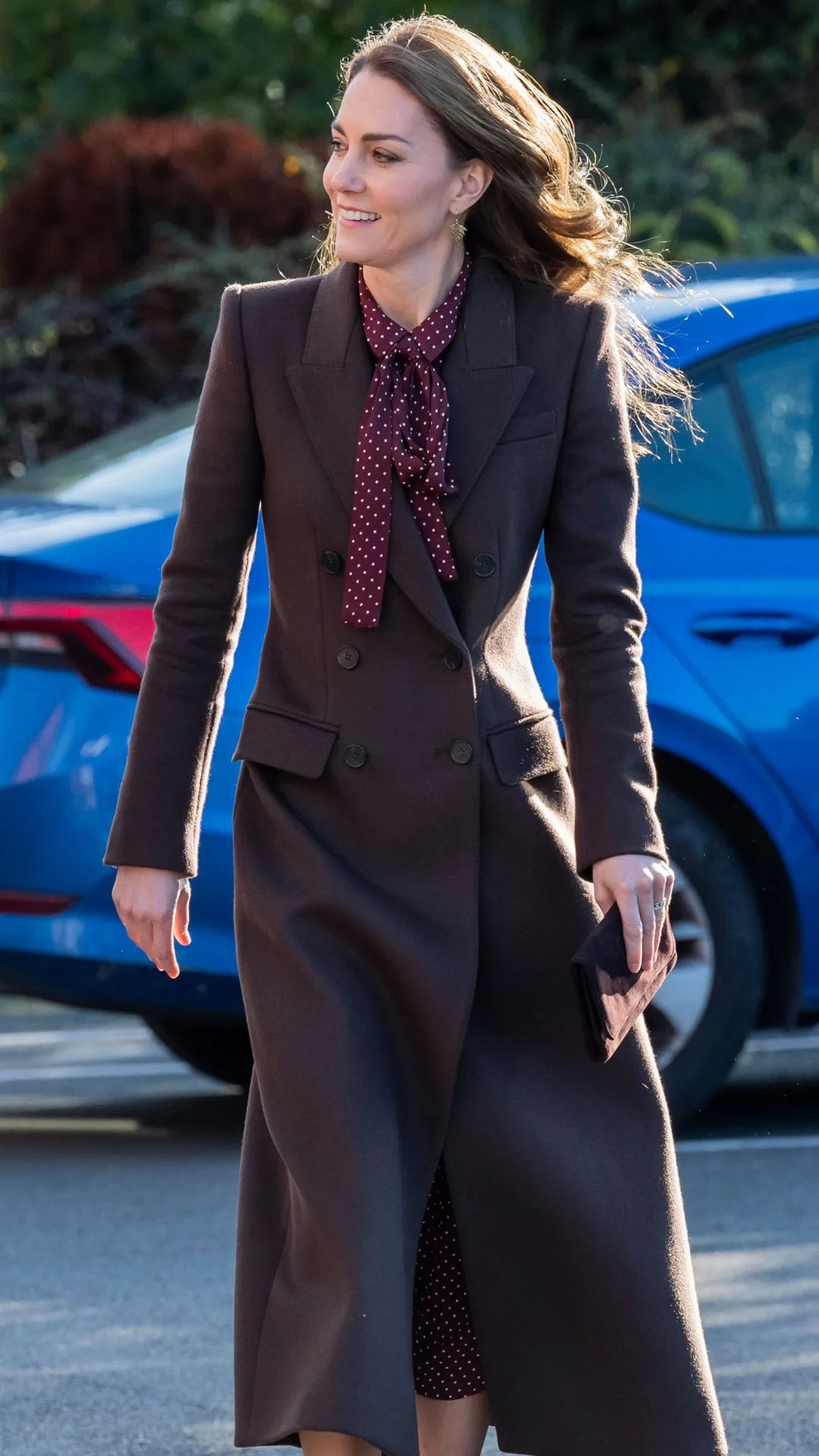  Catherine, Princess of Wales arrives for a visit to Southport Community Centre on October 10, 2024 wearing a dark brown coat with a brown polkadot scarf for a chic Kate Middleton fashion moment.