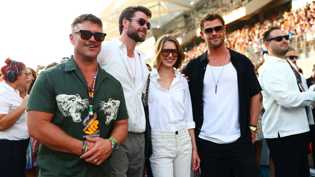 Luke Hemsworth, Liam Hemsworth, Gabriella Brooks and Chris Hemsworth pose for a photo on the grid prior to the F1 Grand Prix of Abu Dhabi at Yas Marina Circuit on November 26, 2023