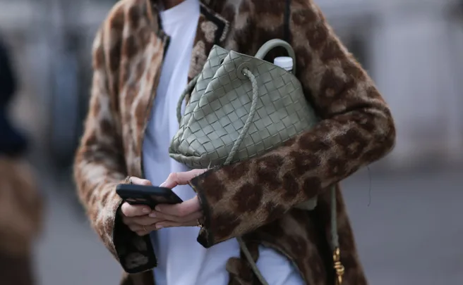 Fashion Week guest shopping on her phone