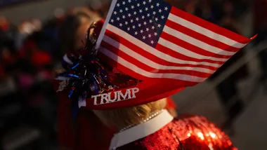 Trump vocabulary. A supporter wears a hat with an American flag and a bejeweled "Trump" pin during a campaign rally for former US President and Republican presidential candidate Donald Trump.