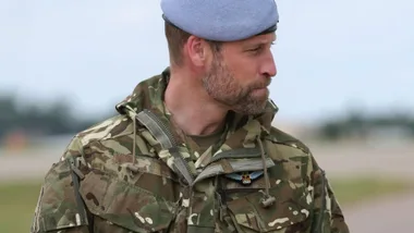 A man wearing an army uniform looking to the side.