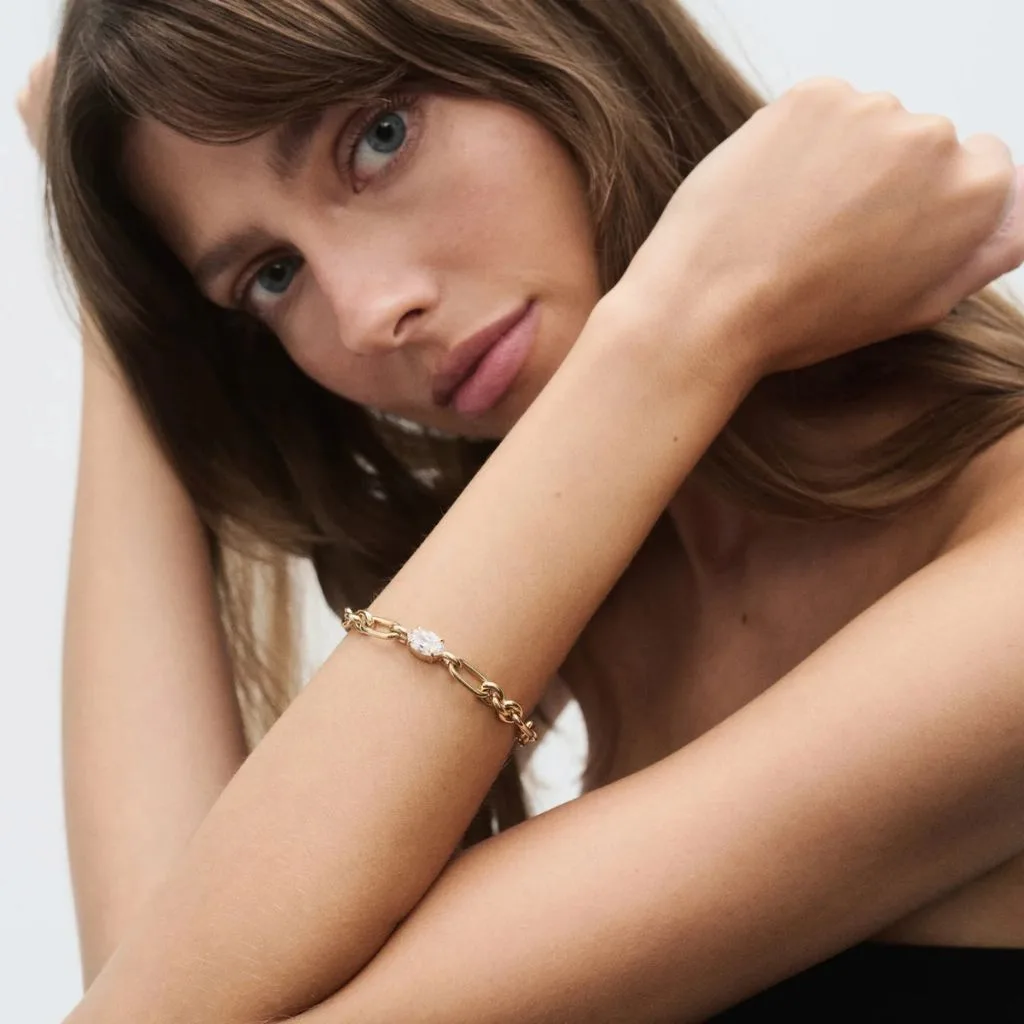 A woman wearing a diamond and gold bracelet.