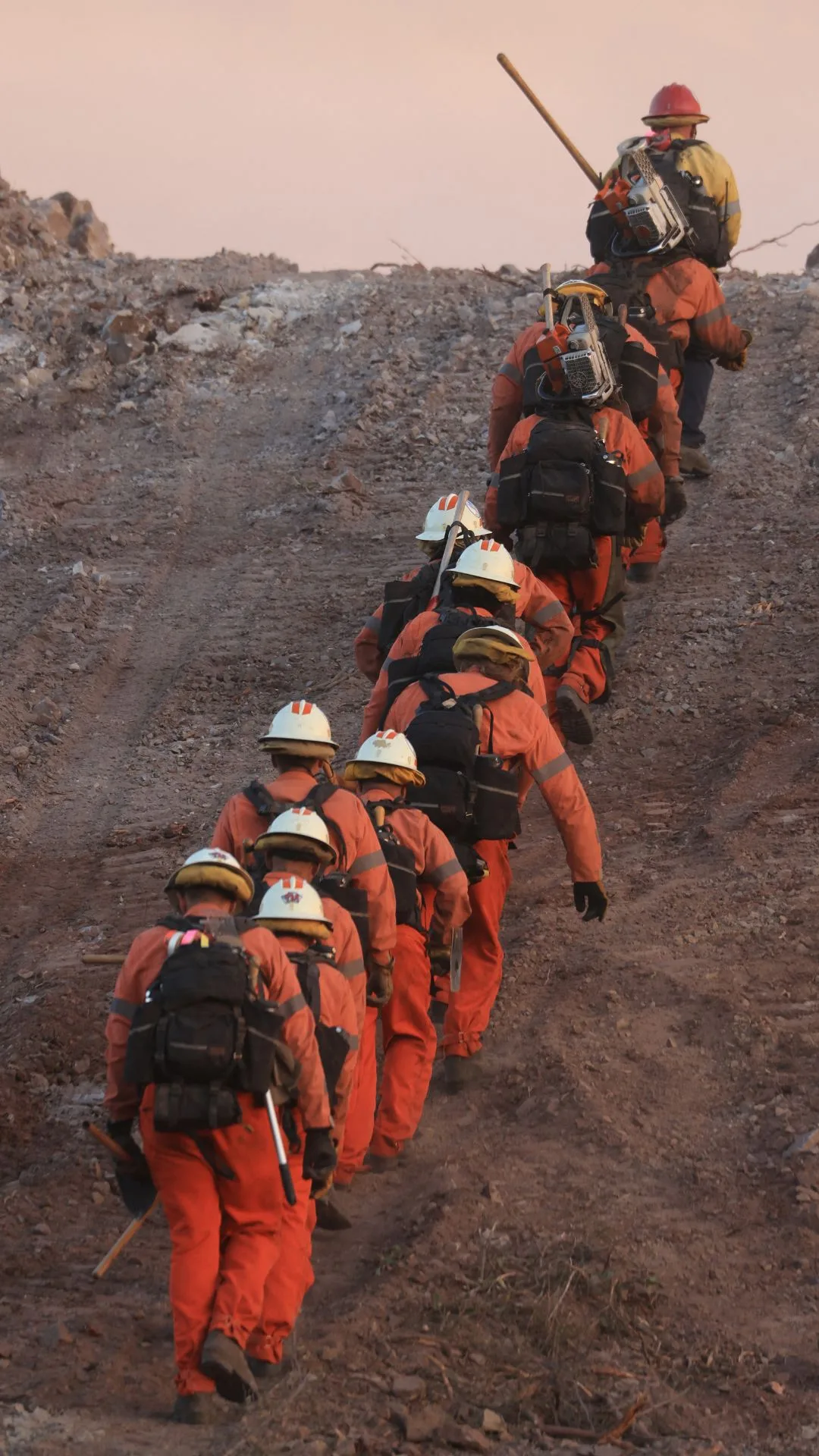 An inmate firecrew walks up a hill to battle the Franklin Fire as it grows in Malibu, California