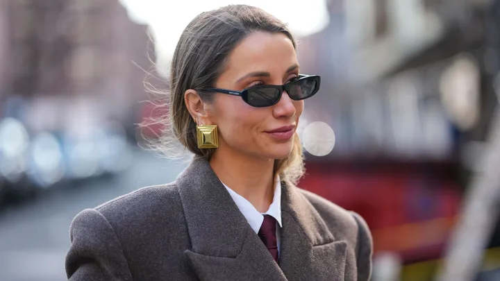 Woman wearing sunglasses and gold statement earrings