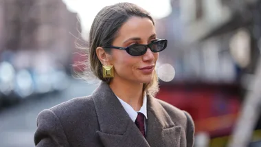 Woman wearing sunglasses and gold statement earrings