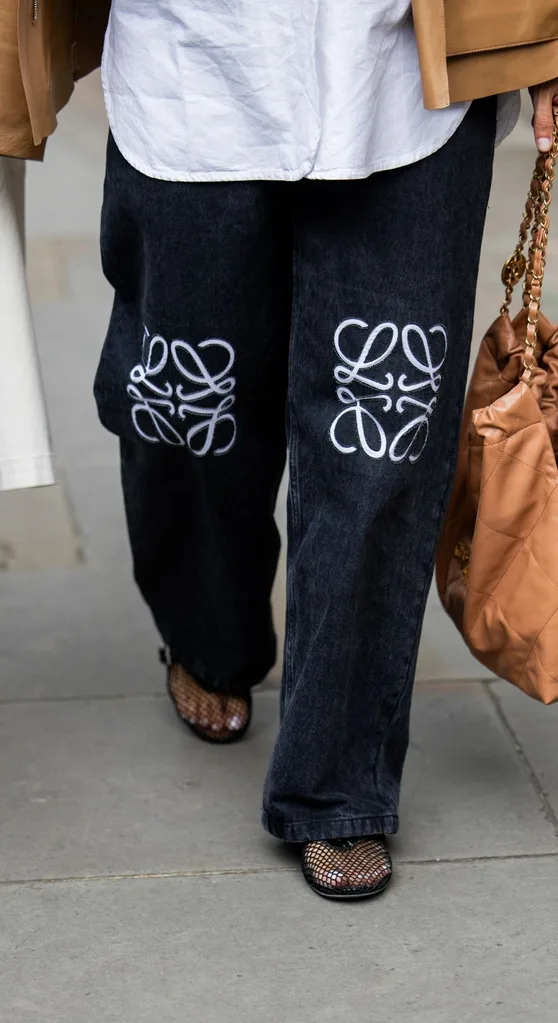 Person wearing loewe jeans, mesh ballet flats, and a white shirt