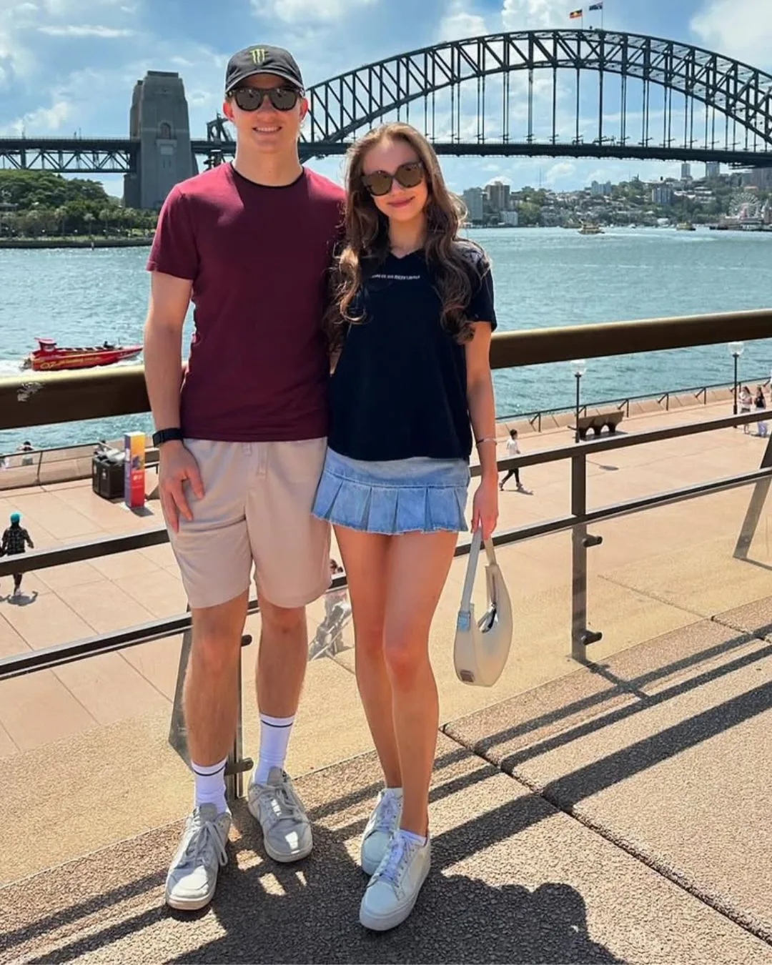 A man and woman standing in front of the Sydney Harbour Bridge. 