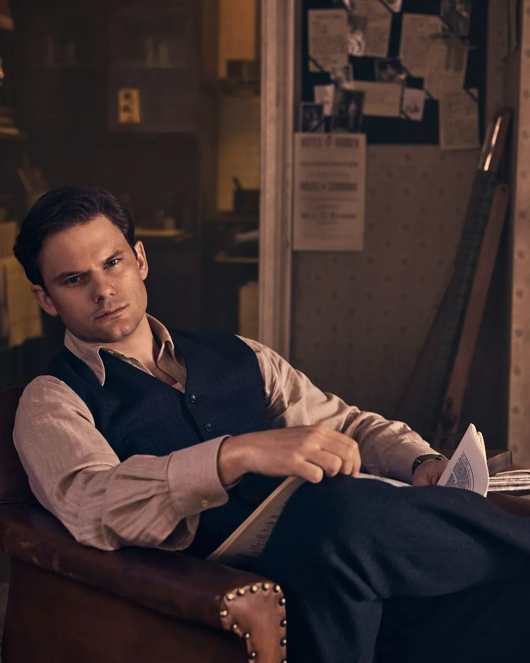 A man sitting in a chair reading a book. 