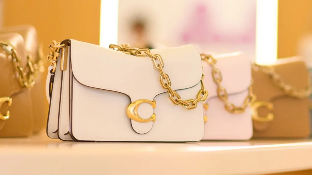 A picture of three Coach handbags presented on a table.