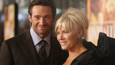 A man wearing a suit next to a woman with blonde hair smiling.