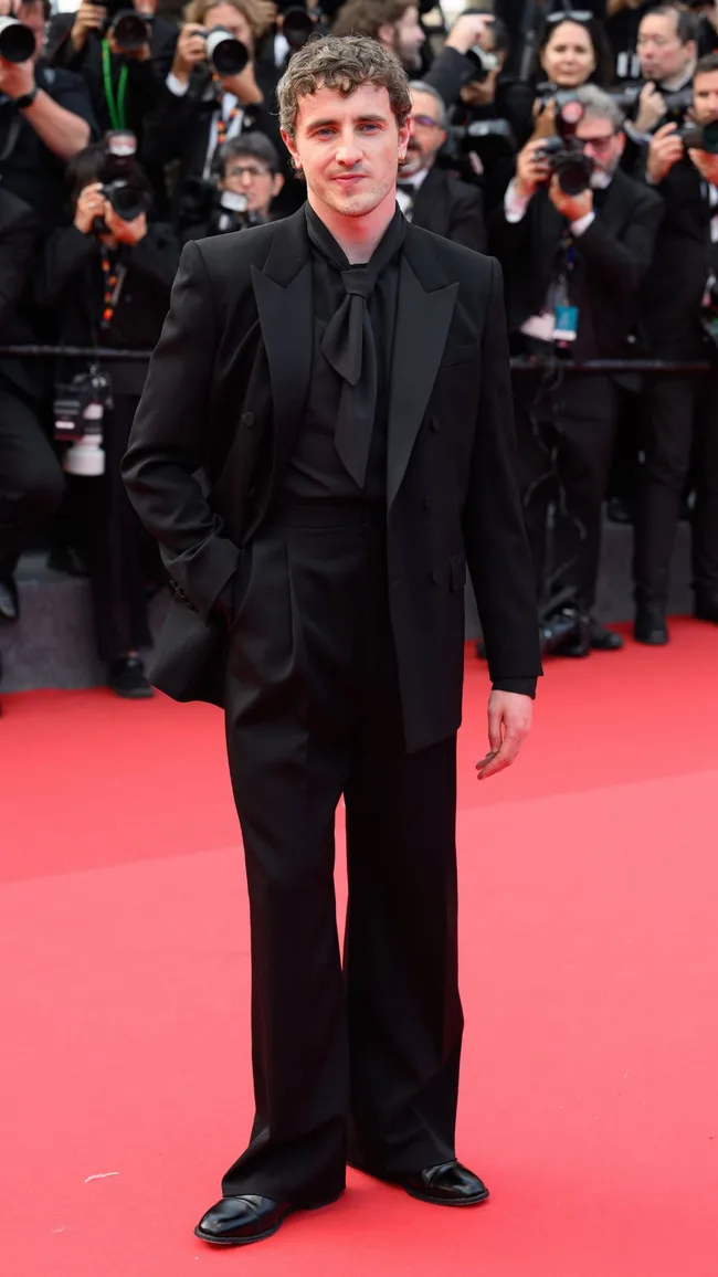 A man wearing a black suit with black shirt