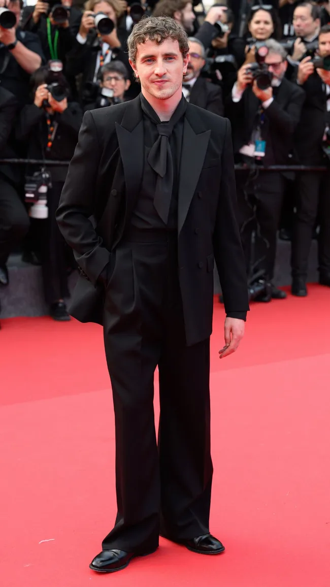 A man wearing a black suit with black shirt