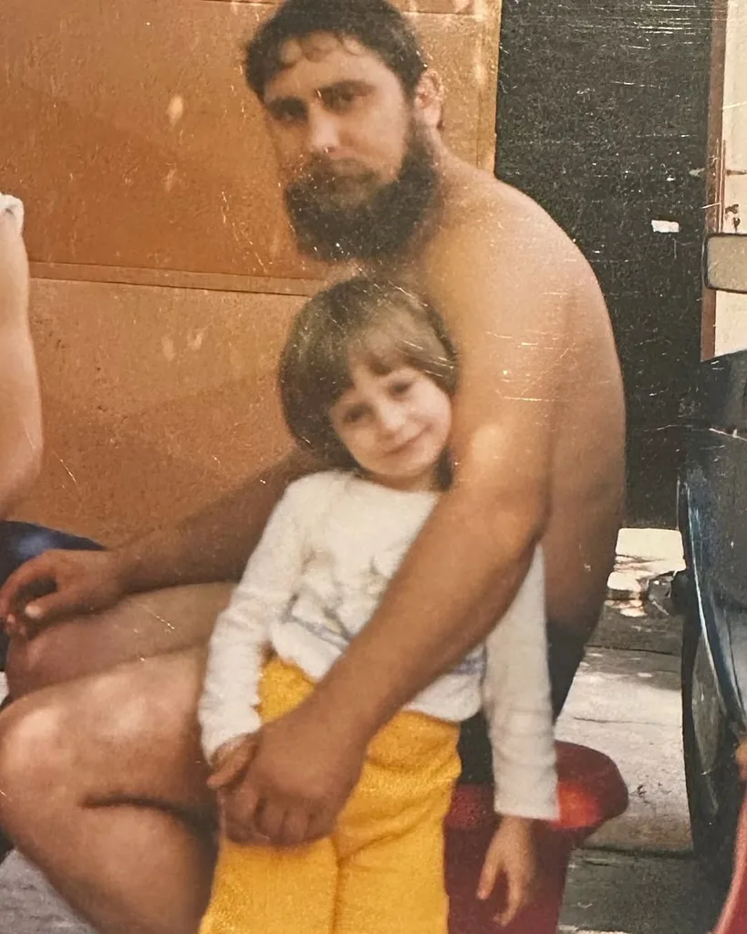 An old photo depicting a man with his young child.