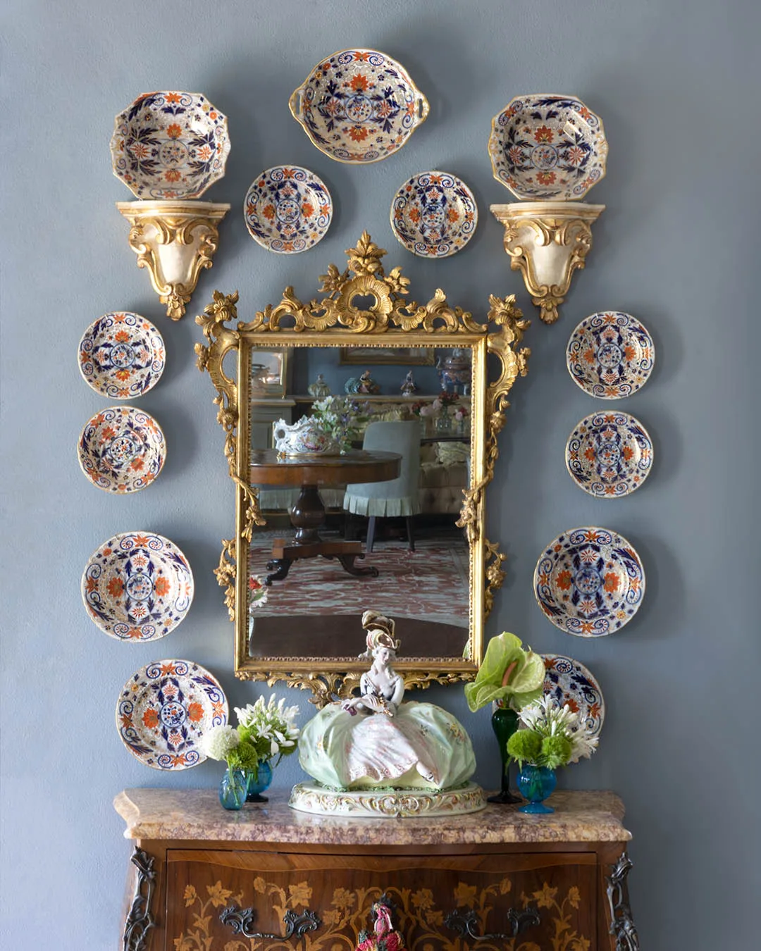 A collection of Fischer and Mieg plates from the late 1800s encircle an antique gilded mirror. 