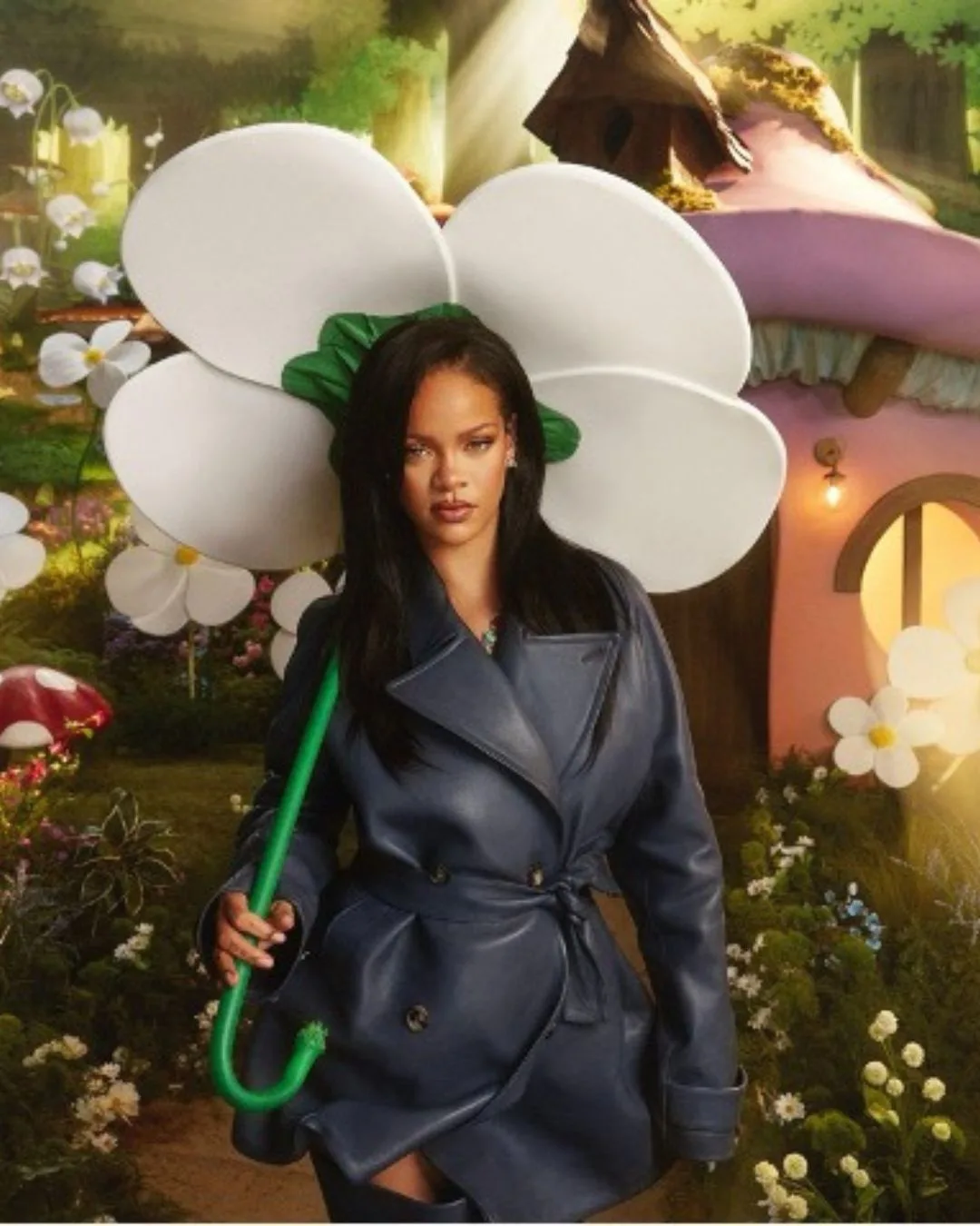 Rihanna posing under a flower umbrella wearing a navy coat to announce her new song from the Smurfs soundtrack.