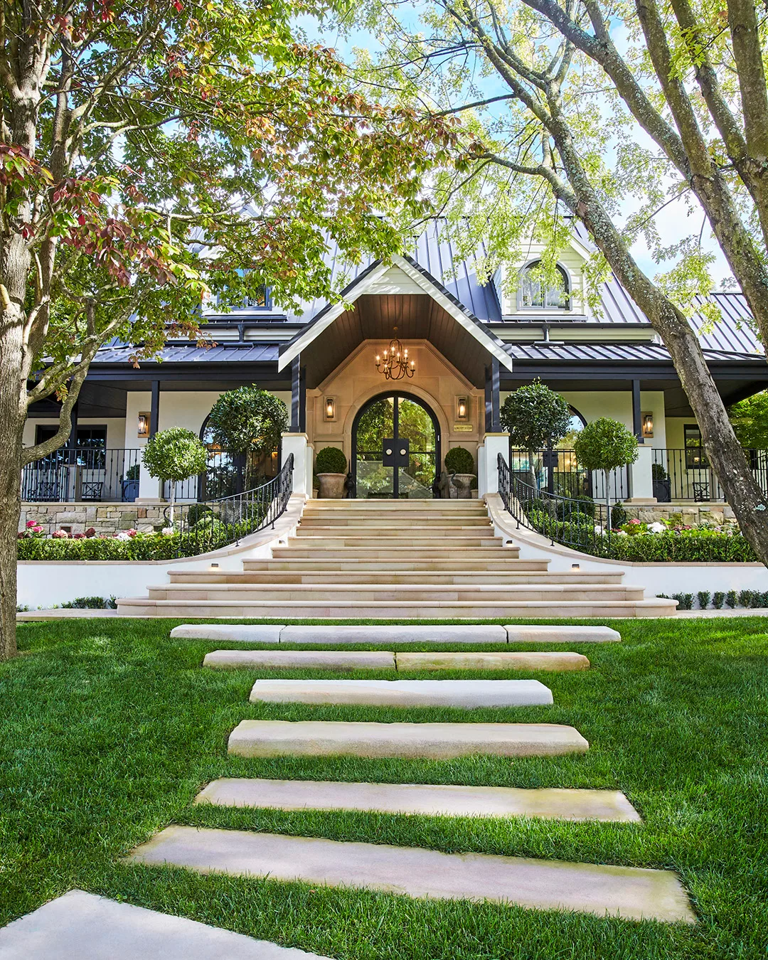A picture of a paved garden path leading to a house with a pitched roof. 