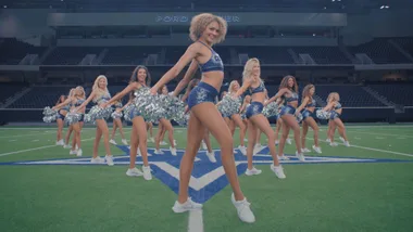 A still image of dallas cheerleaders on the field lined up.