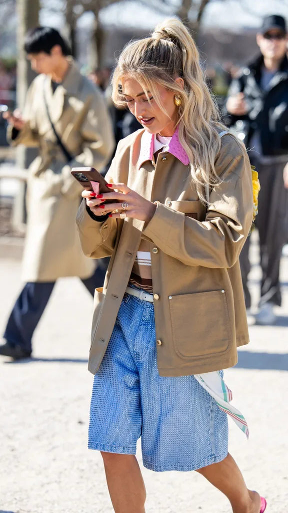 Emili Sindlev street style on phone wearing jacket