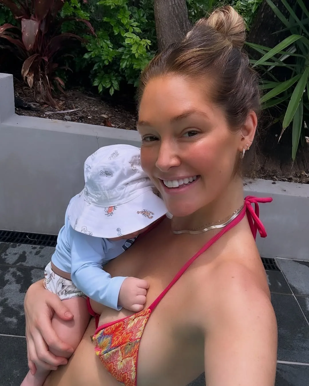 A smiling woman holding her newborn baby. 