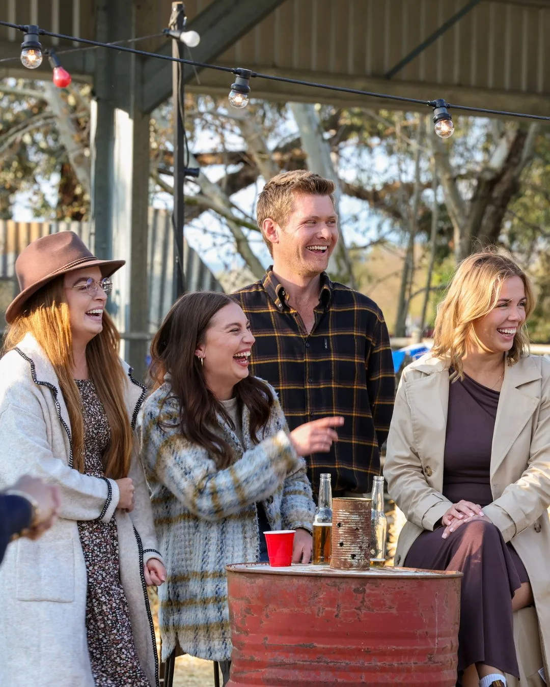 A man laughs with a group of three women. 