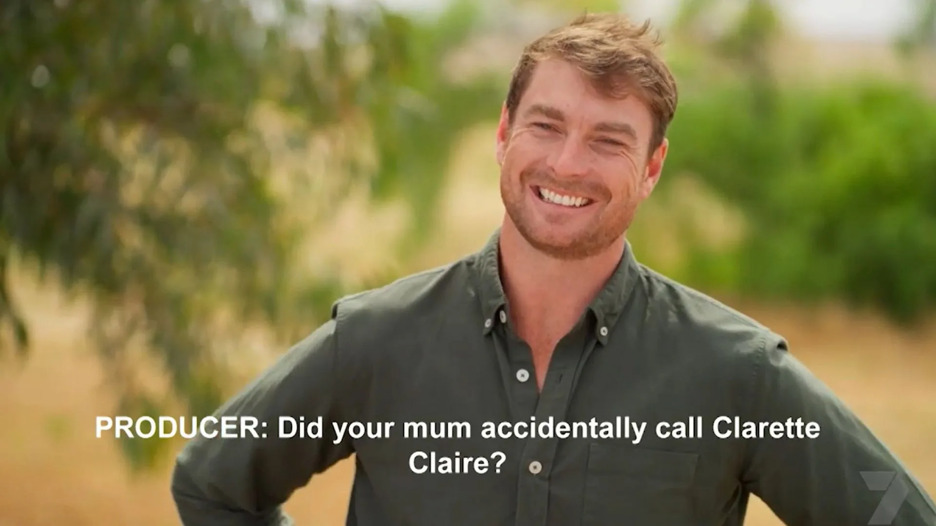 A man smiling awkwardly to the camera. 