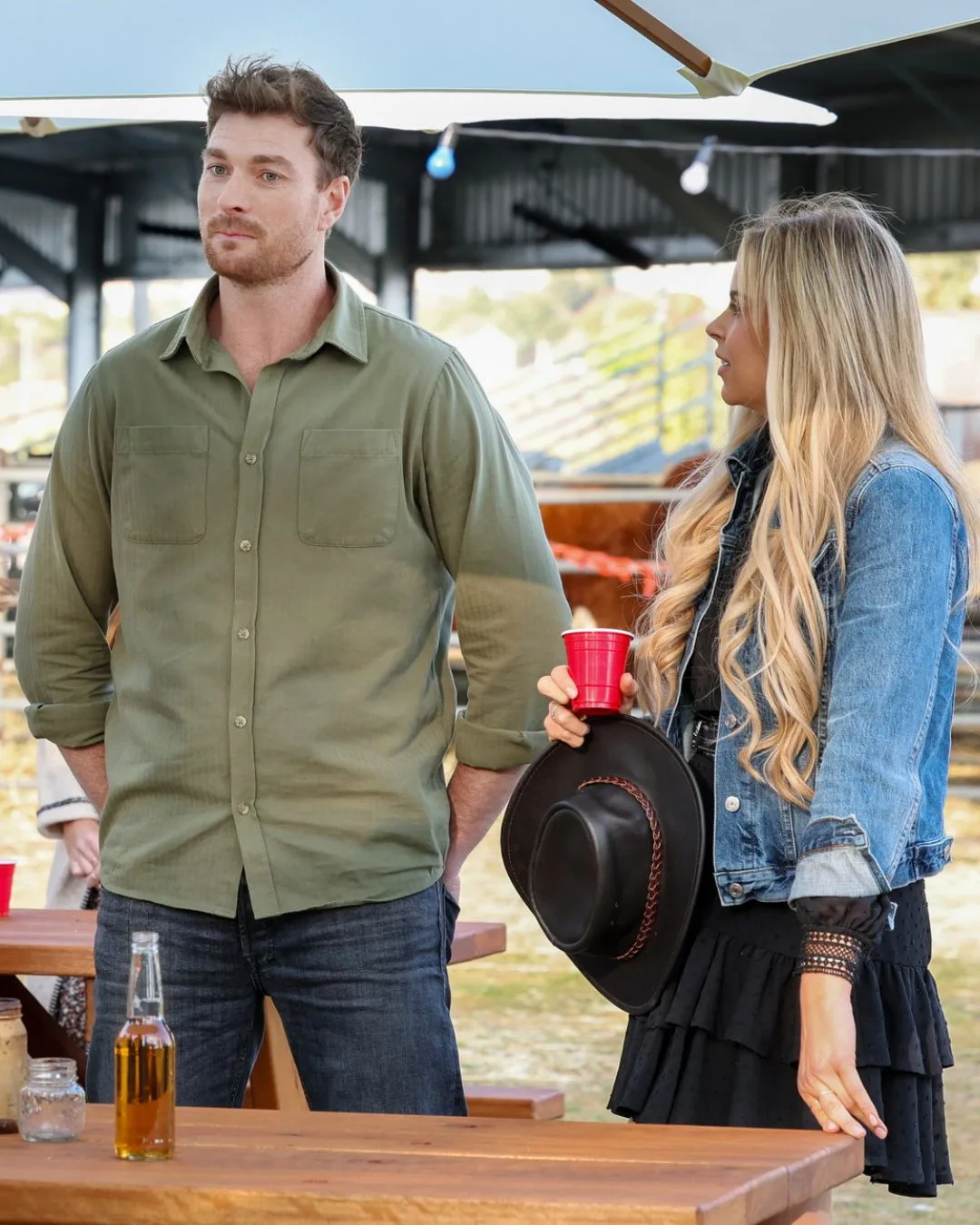 A man wearing a green shirt and a blonde woman standing. 