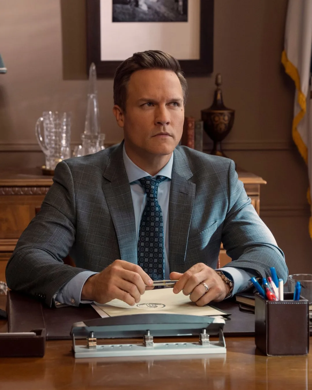 A man wearing a suit sitting at a desk.