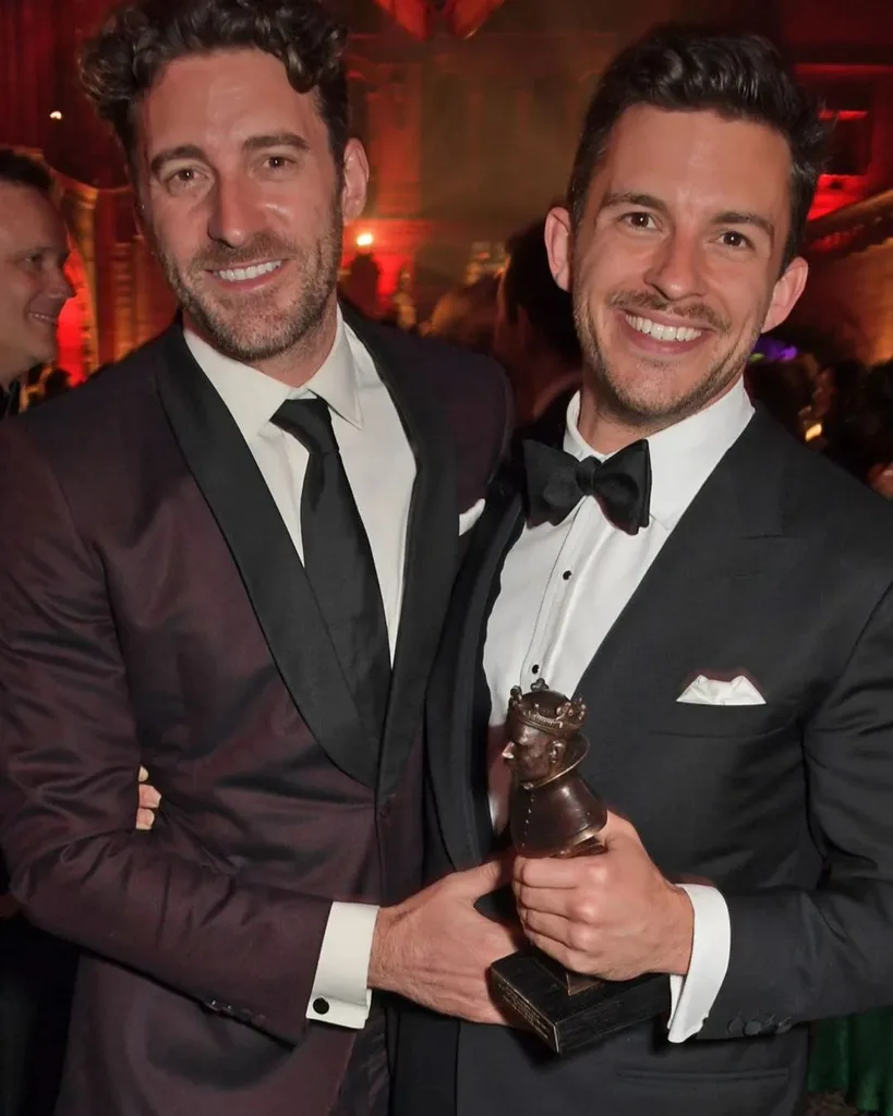 Two men in suits smiling