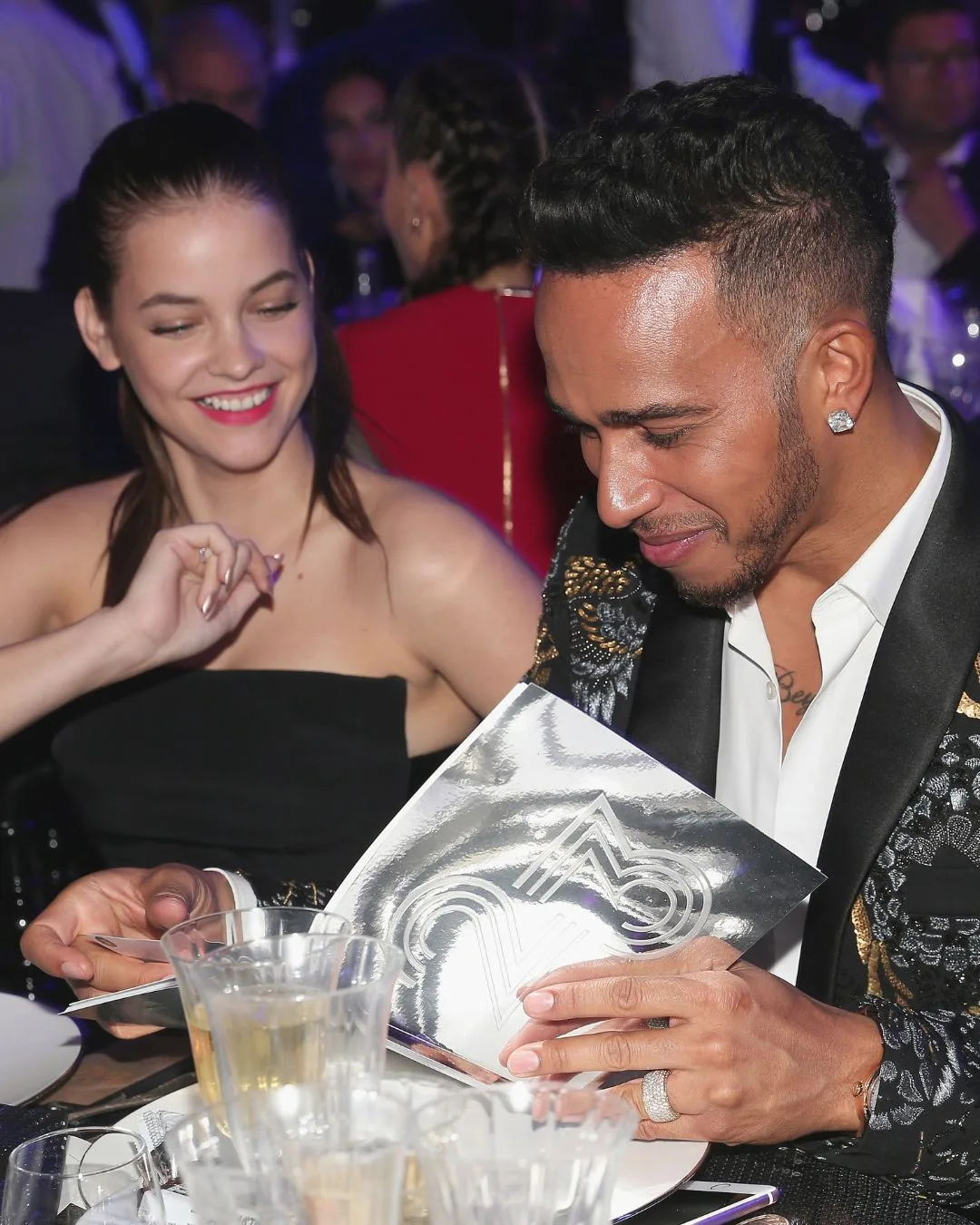 A man and woman sitting at a table smiling while they look at the menu. 