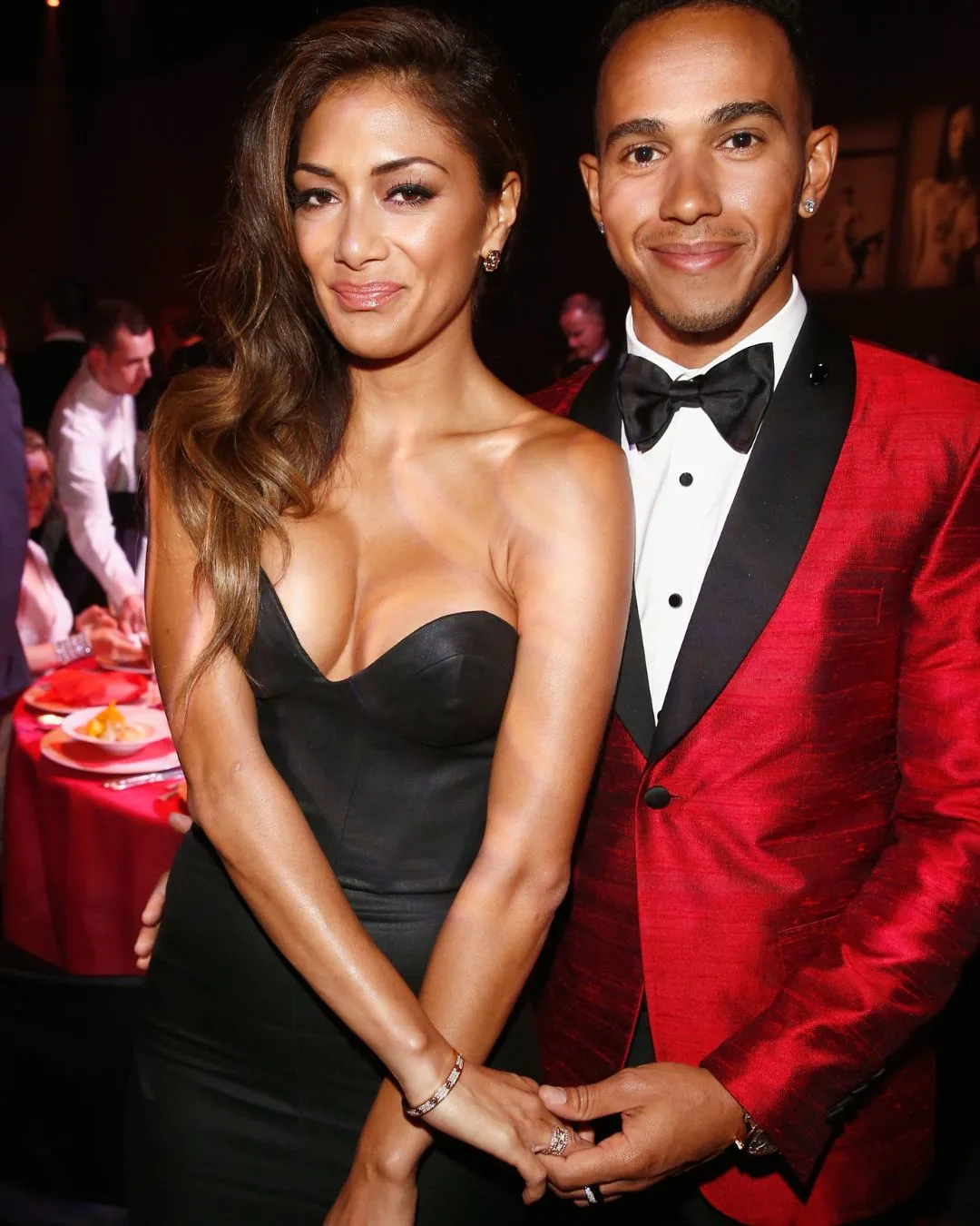A woman and man at a black tie event holding hands and smiling. 
